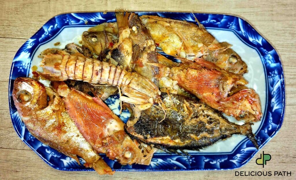 plate of mixed cooked fish from the sea, symbolizing attraction, sailing, and the gathering of different forms into one meal