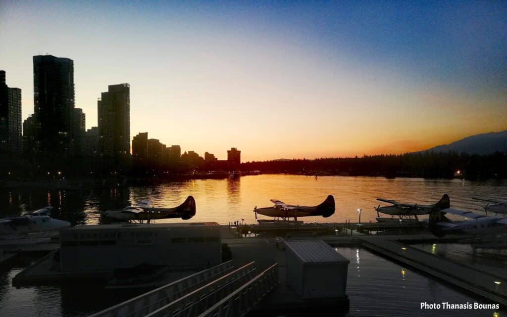 Seaplanes docked in Coal Harbour with Downtown Vancouver skyline at sunset in Vancouver British Columbia Canada