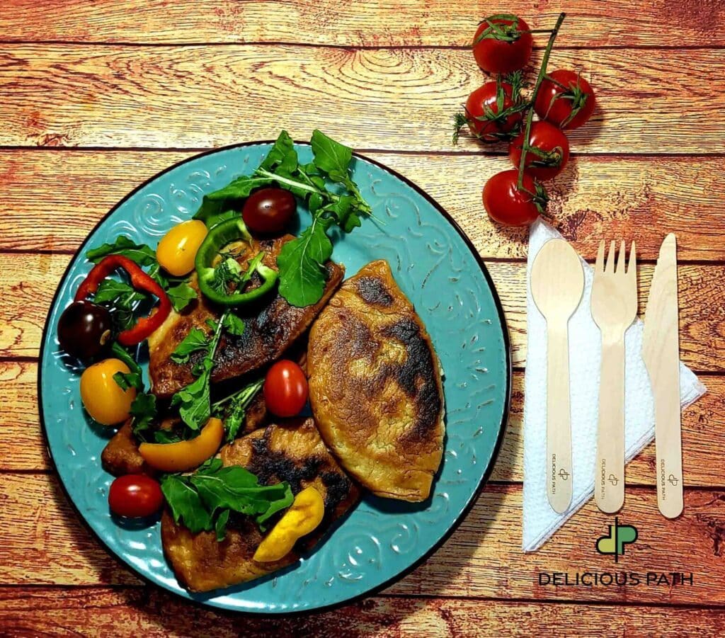 Plate of grilled pies with fresh vegetables on a wooden table, symbolizing patience, food, and slow travel by sea