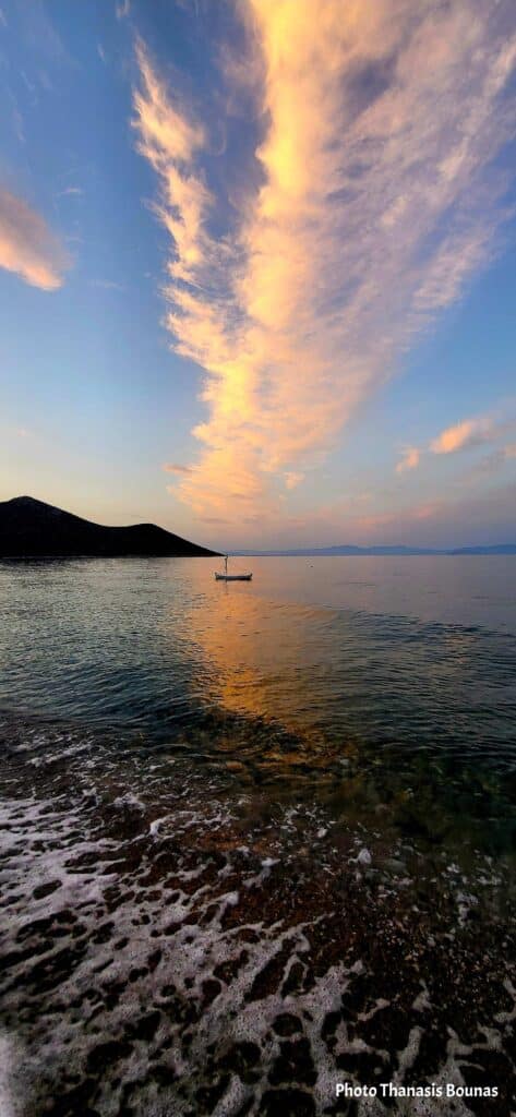 Sunset over the sea in Tyros Arcadia Peloponnese with a small boat and colorful sky