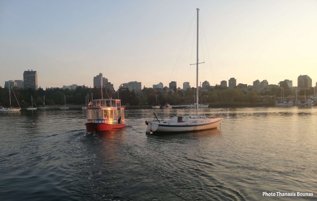 False Creek ferry boat with sailboats and Vancouver skyline at sunset British Columbia Canada