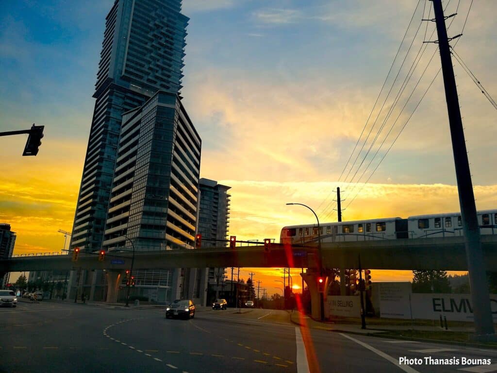 SkyTrain on elevated track at sunset near modern high rise buildings in Burquitlam British Columbia Canada
