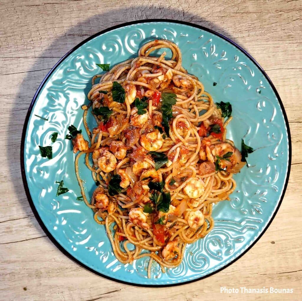Plate of spaghetti with shrimp, tomato sauce, and fresh parsley
