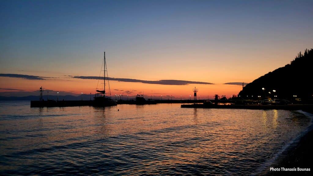 Sunrise at Tyros Arcadia Greece with calm sea and small harbor boats