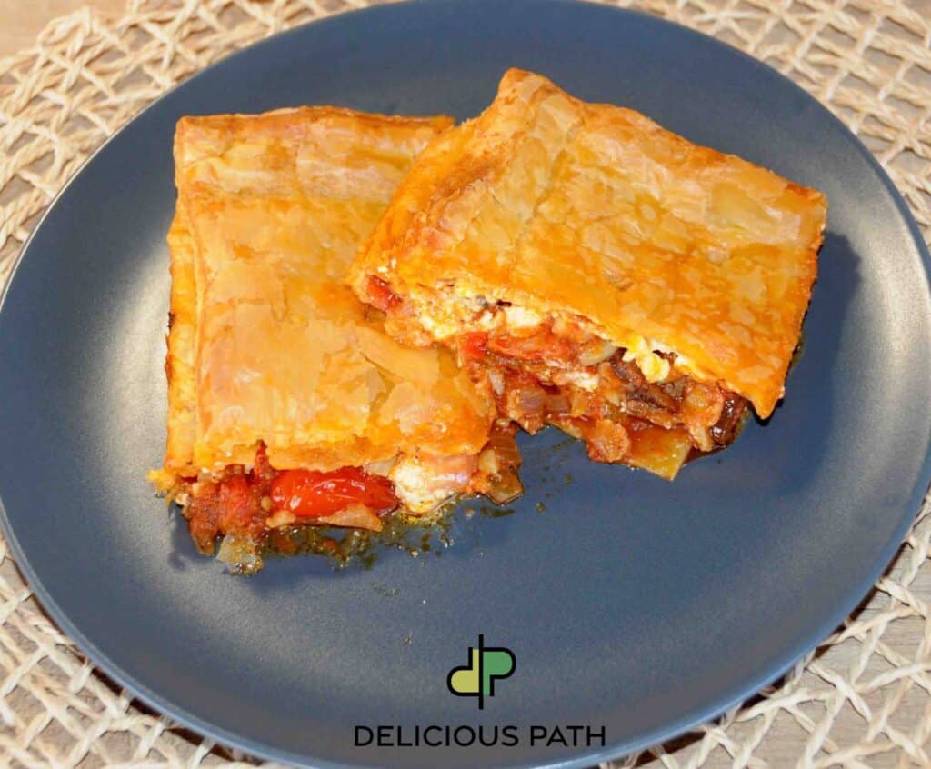 Two slices of golden tomato pie on dark plate symbolizing arrival after sailing journey
