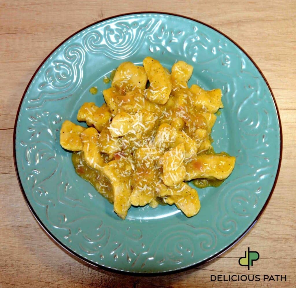 Turquoise plate with gnocchi in golden sauce on wooden table symbolizing calm preparation connected to sailing philosophy