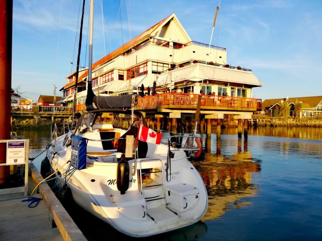 Boat docked at Steveston Harbour with Steveston Seafood House Steveston Village Richmond British Columbia Canada
