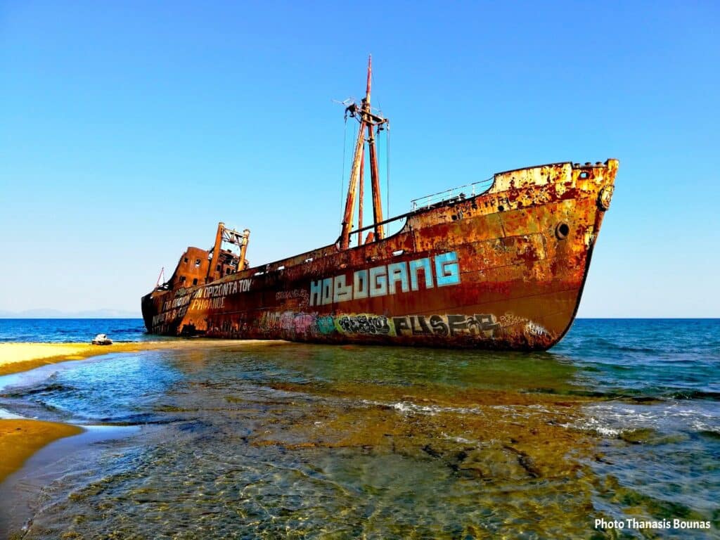 Abandoned ship on shallow sea shore symbolizing connection, sailing psychology, memory, and the enduring bond between vessel and sea