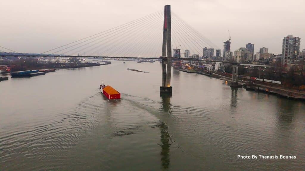 SkyBridge over Fraser River in British Columbia Canada with boat moving across water
