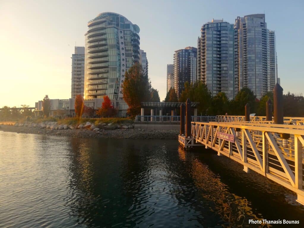 Waterfront residential towers and marina pier at sunset in Vancouver British Columbia Canada
