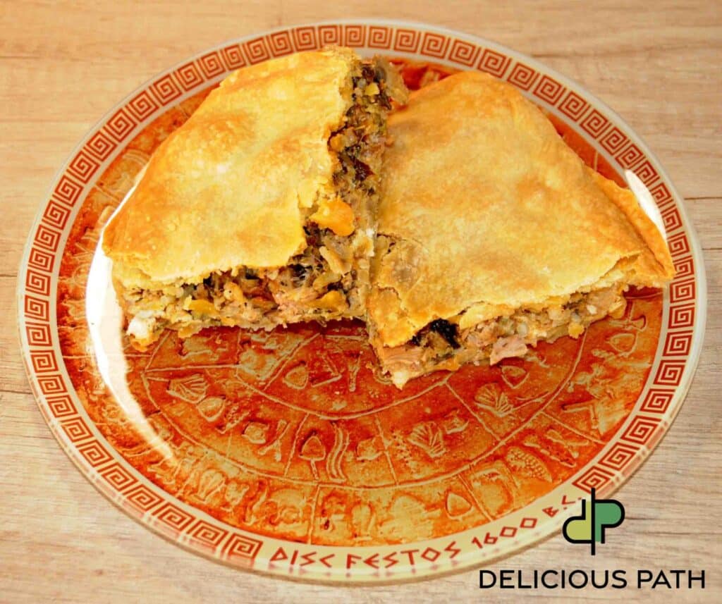 Golden homemade meat pie cut in half on a red patterned plate, symbolizing listening, travel psychology, and the quiet joy of sailing journeys.