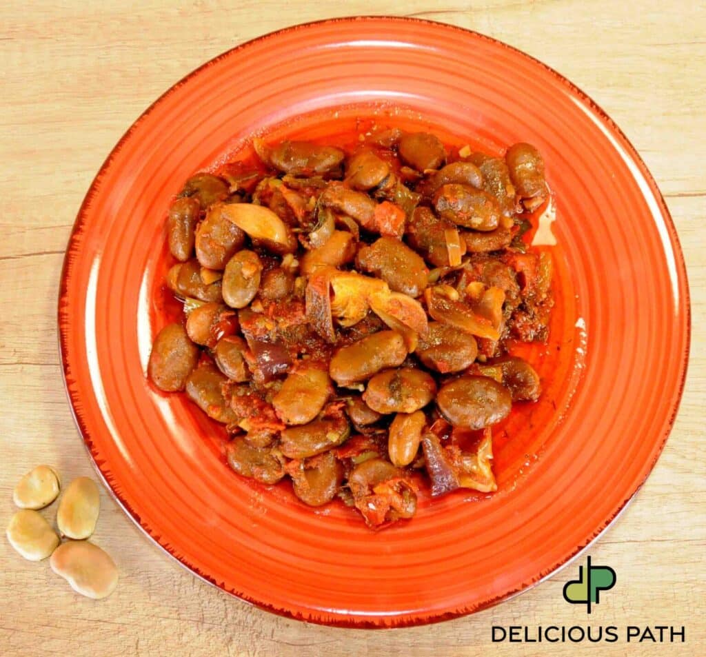 Braised broad beans with tomato and garlic on red plate symbolizing home after sailing journey