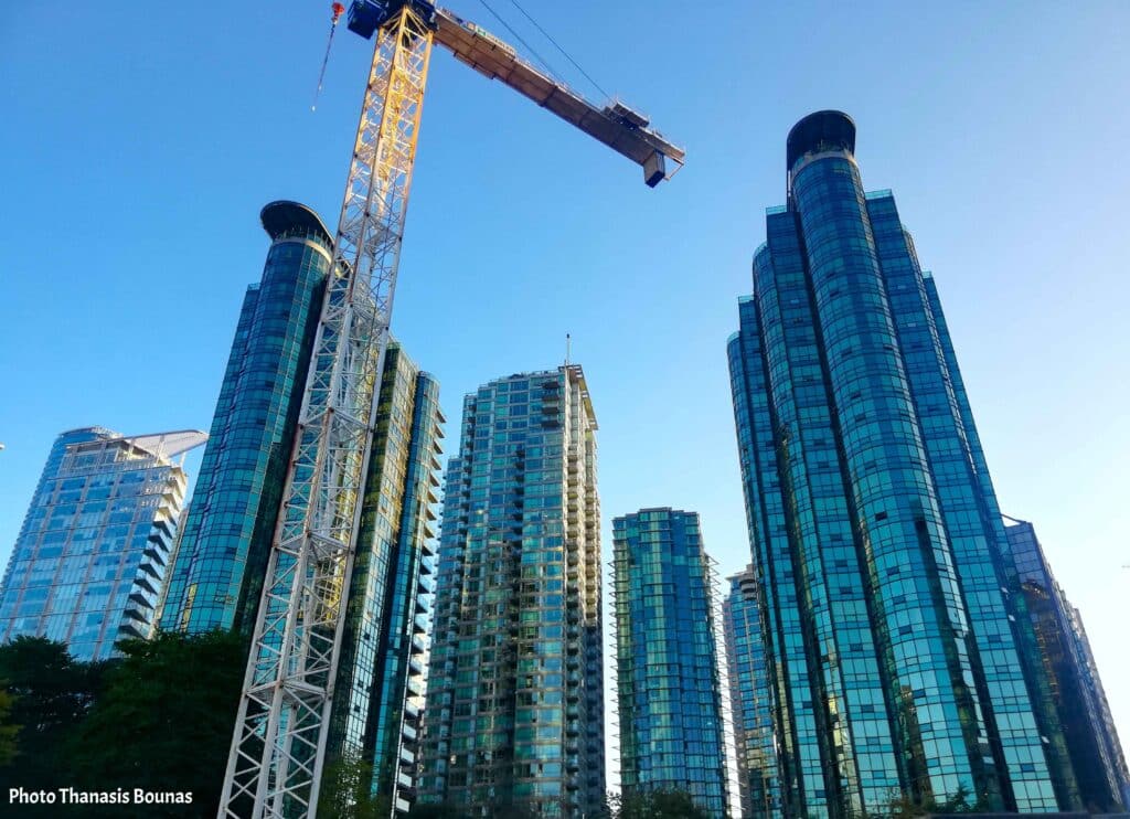 Modern glass skyscrapers and construction crane in downtown Vancouver British Columbia Canada