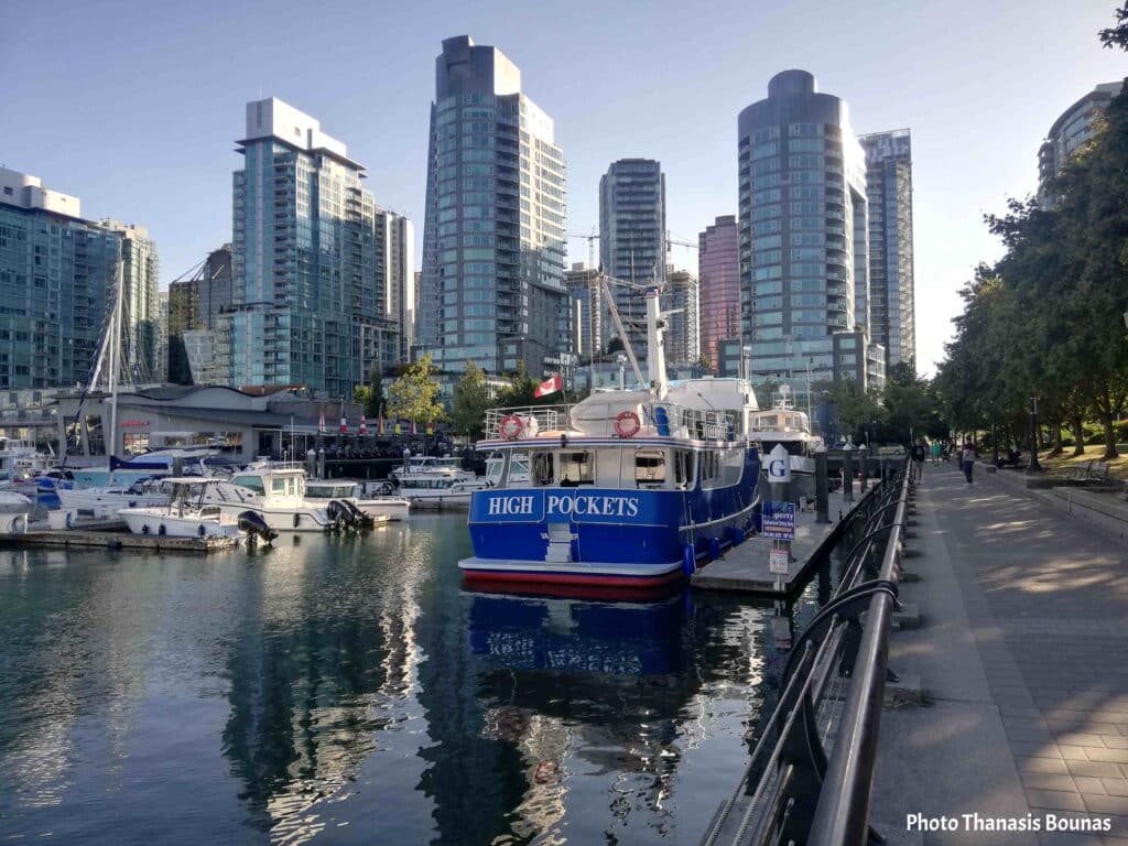 Boat at marina near Cardero Park Coal Harbour with Vancouver skyline British Columbia Canada