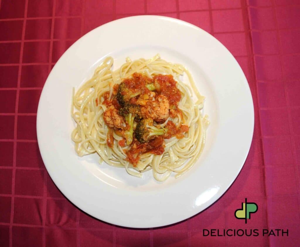 Plate of pasta with tomato sauce and vegetables, symbolizing loss, nourishment, and the quiet psychology of Sailing and travel.