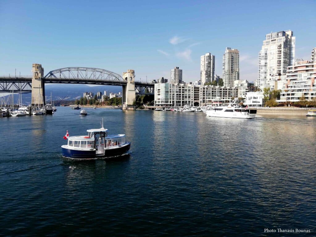 Aquabus boat in False Creek with Burrard Street Bridge and Vancouver skyline Vancouver British Columbia Canada
