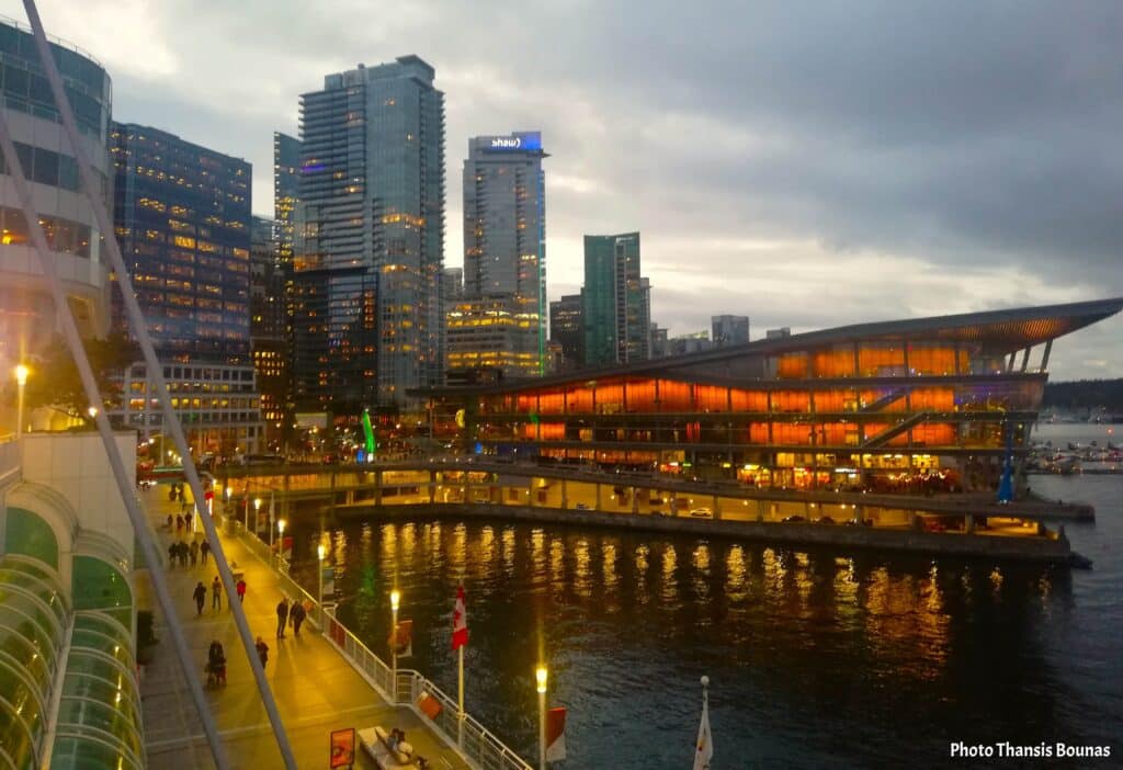 Canada Place Vancouver at sunset with city lights reflecting on the water