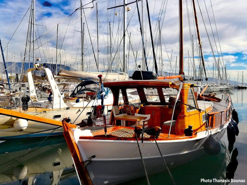 Wooden sailboat in marina symbolizing sailing solitude and travel psychology