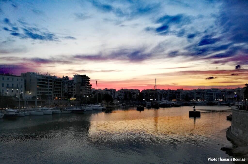 Zea Marina Piraeus sunset with boats and city skyline Greece