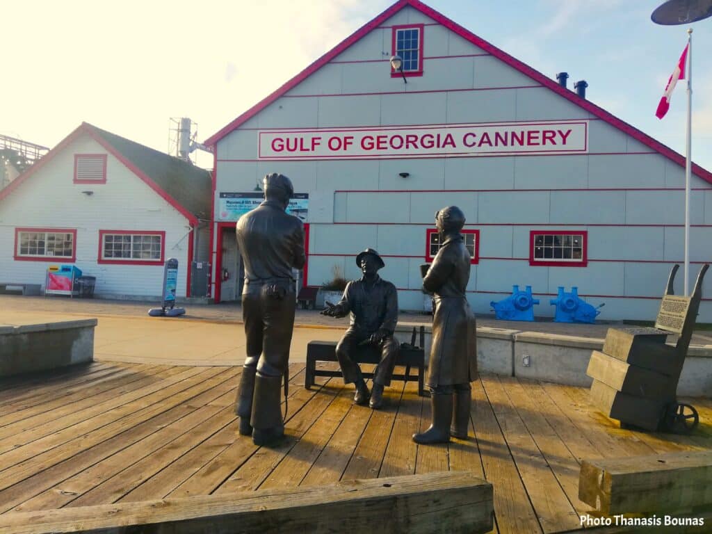 Statues of fishermen in front of the Gulf of Georgia Cannery in Steveston, Canada, symbolizing maritime labor and travel reflection