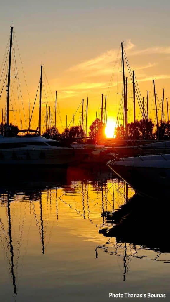 Sailboats resting in a marina at sunset reflecting on calm water symbolizing stillness in sailing and travel psychology