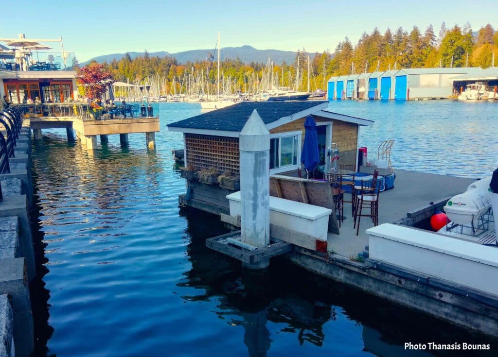 Marina with floating dock house boats and waterfront restaurant in Vancouver British Columbia Canada
