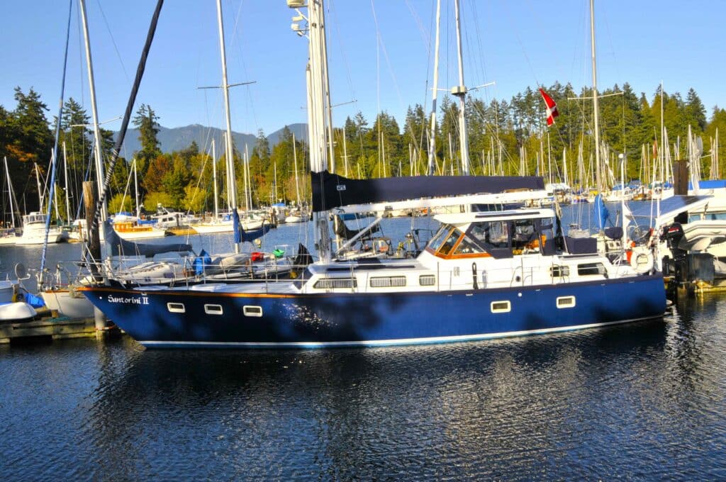 Sailboat at marina in North Vancouver with forest and mountains British Columbia Canada
