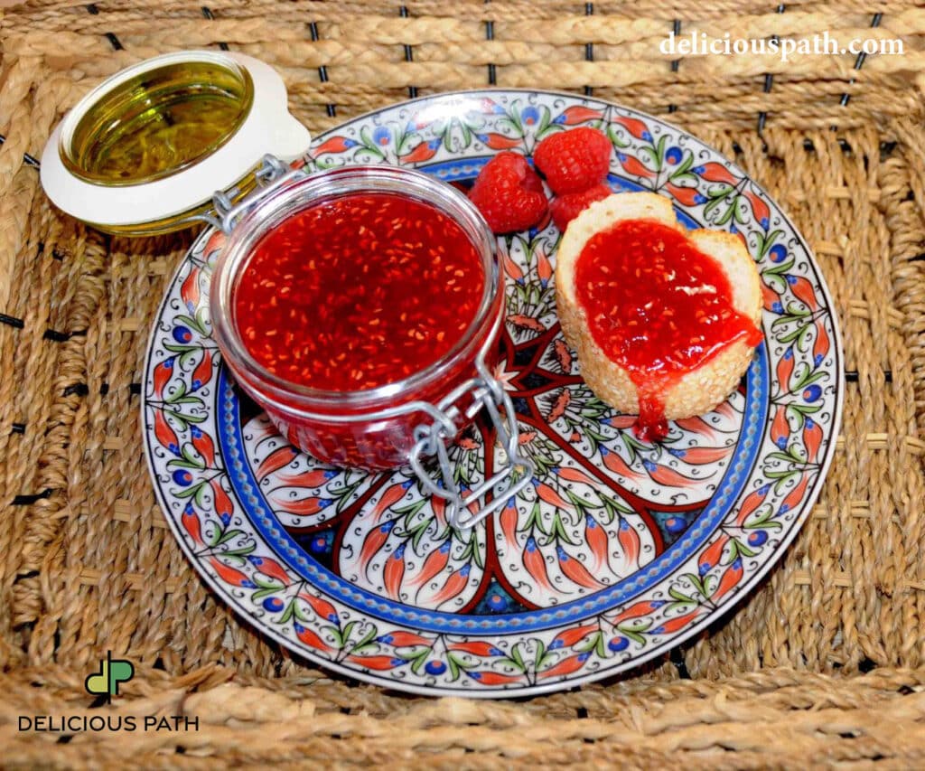 Raspberry jam in glass jar with bread and fresh raspberries on decorative plate, symbolizing shadow, food and sailing psychology