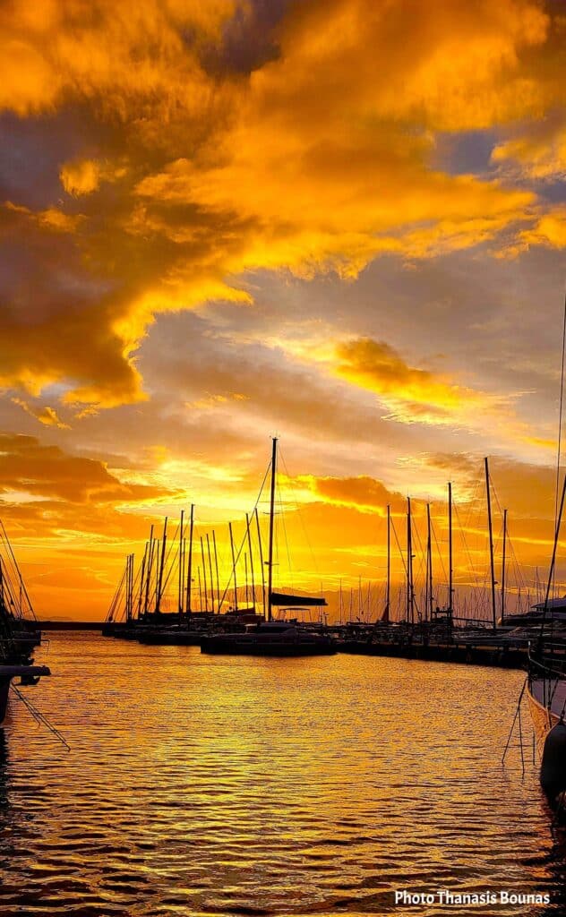 Golden sunset over marina with sailboat masts and reflective water, symbolizing fragility and sailing psychology