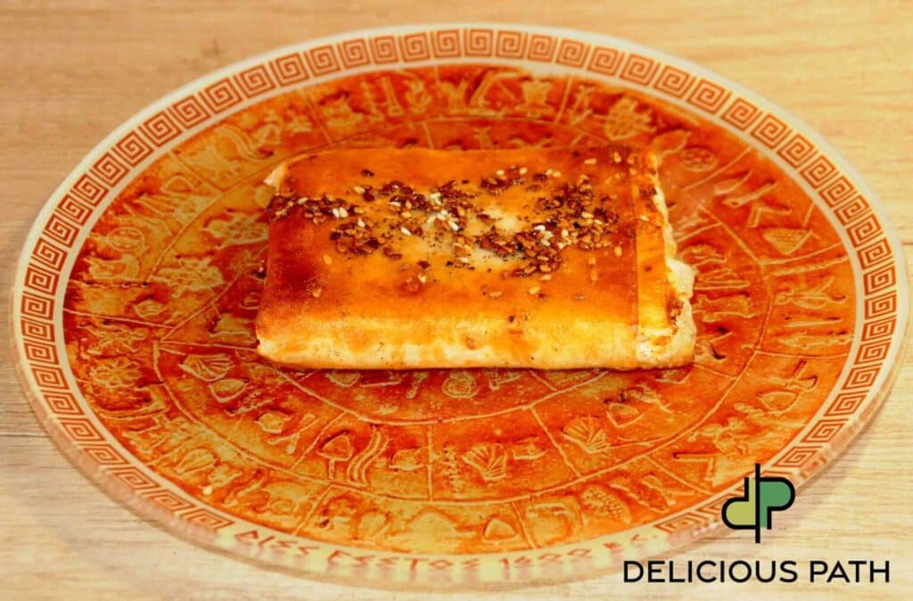 Golden saganaki with feta and phyllo pastry on decorative plate symbolizing strength and balance