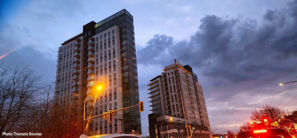 Vancouver streets at sunset with dramatic clouds and city lights reflecting on modern buildings