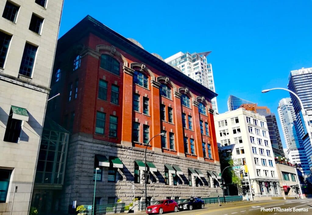 Historic red brick building in downtown Vancouver surrounded by modern architecture in British Columbia Canada