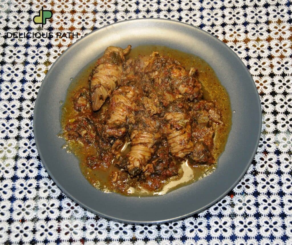 Traditional dish in rich tomato sauce on grey plate symbolizing thirst and psychological longing connected to sailing philosophy