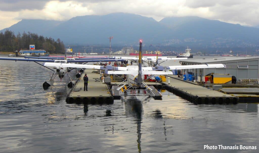 Vancouver harbour floatplanes docked at the waterfront with mountains in the background British Columbia Canada
