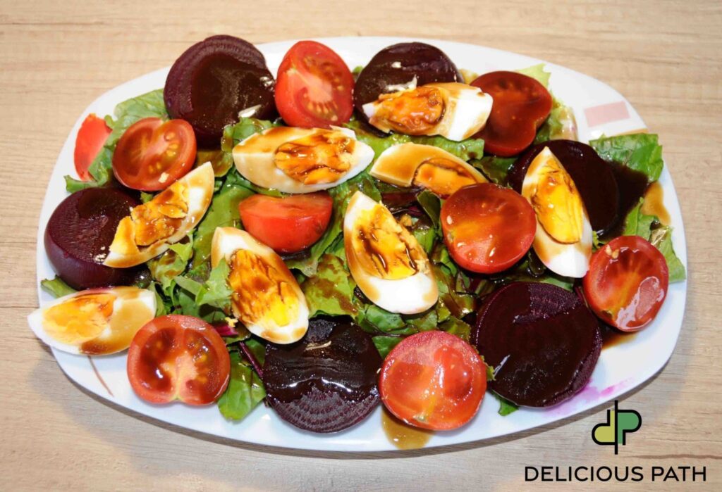 Fresh salad with lettuce, cherry tomatoes, beetroot slices, and boiled eggs drizzled with dressing