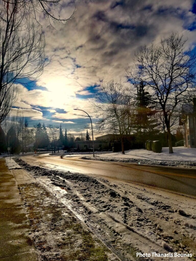winter street in Canada with snow and sunlight reflecting on icy road