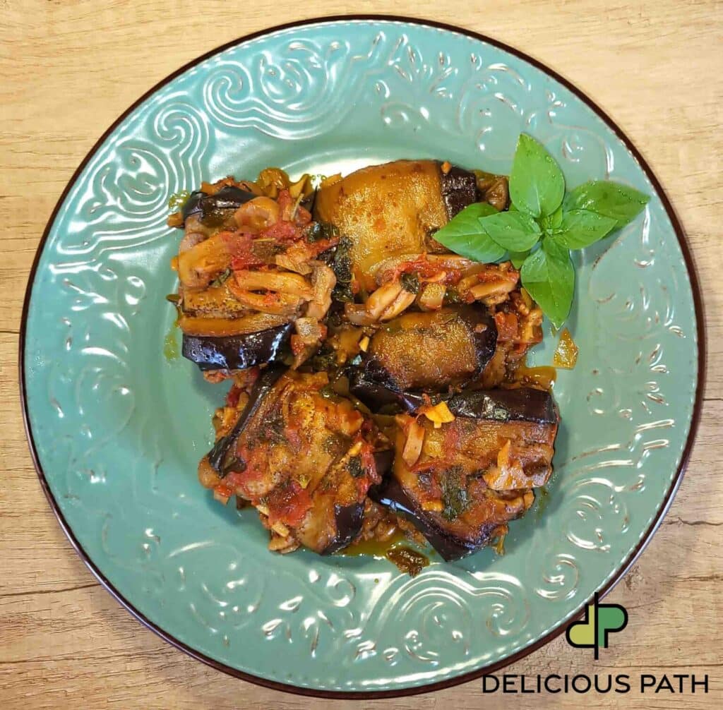 Turquoise plate with stuffed eggplant in tomato sauce symbolizing warmth and psychological comfort connected to sailing philosophy