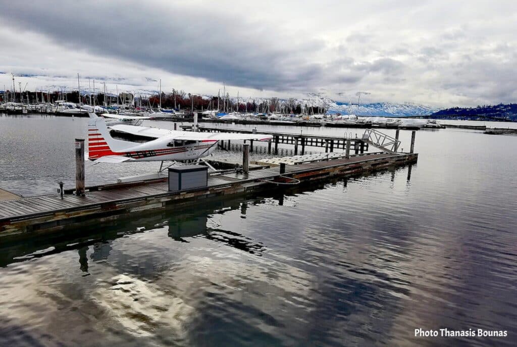 Seaplane docked on Okanagan Lake in Kelowna British Columbia with mountains and marina