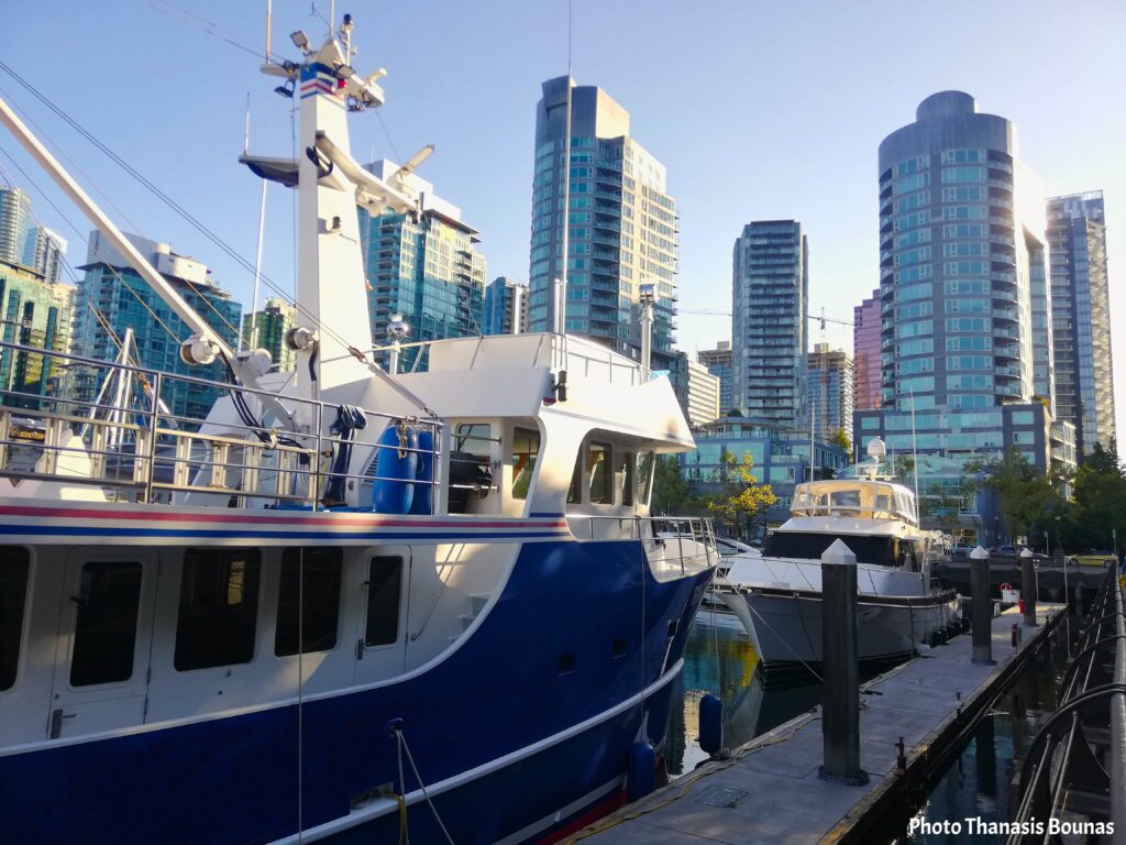 Boats docked at the marina near Cardero Park with Vancouver skyline in the background
