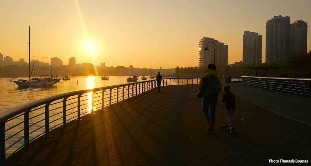 Sunset walk along the seawall at George Wainborn Park in Vancouver with sailboats on False Creek