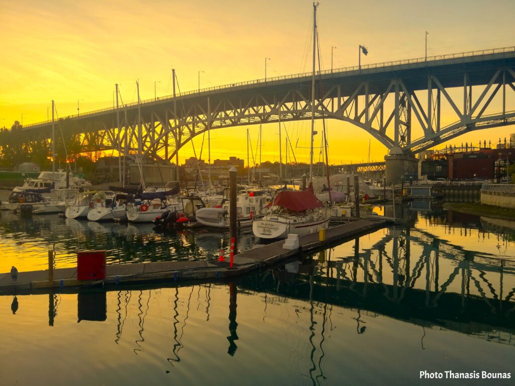 Sailboats resting in False Creek marina beneath Granville Bridge at sunset
