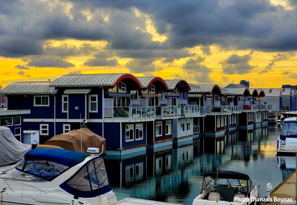 Floating homes and boats reflecting on calm water at Mosquito Creek Marina in North Vancouver during sunset travel moment