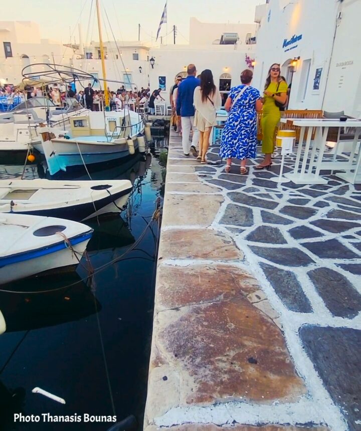 An evening walk beside the harbor in Paros, surrounded by small boats and the traditional atmosphere of the Cyclades. Photo by Thanasis Bounas.