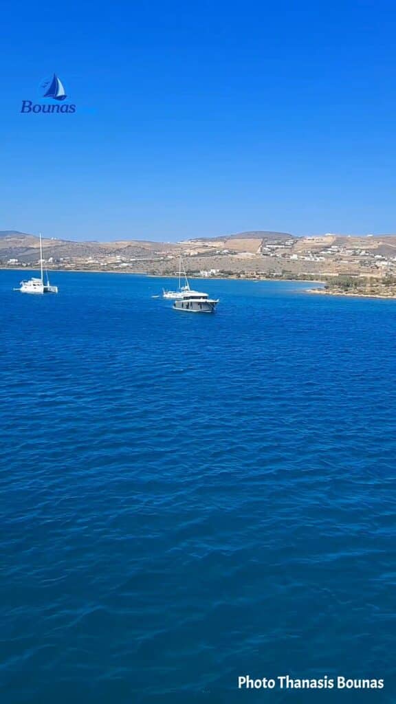 Sailboats anchored in the blue waters of Antiparos, Greece